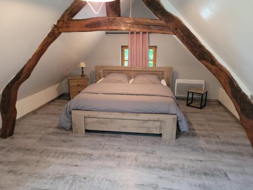 ein Schlafzimmer mit einem Bett im Dachgeschoss in der Unterkunft Maison Campagne Dix Kilomtres De in Hautot-lʼAuvray