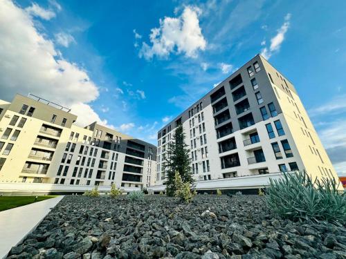 蒂米什瓦拉的住宿－Modern Apartment in Timisoara，两座高大的建筑,有一大堆岩石