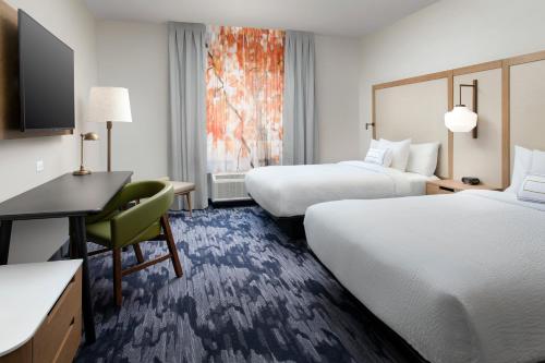 a hotel room with two beds and a desk at Fairfield Inn & Suites by Marriott Denver Tech Center North in Denver