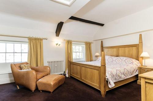 a bedroom with a bed and a chair at Wixey House in Chipping Campden