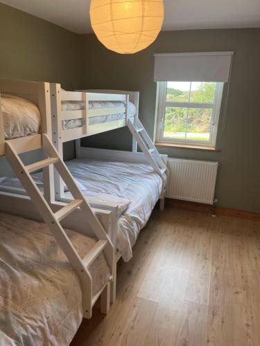 1 dormitorio con 2 literas y ventana en Cúlú, en Kincasslagh