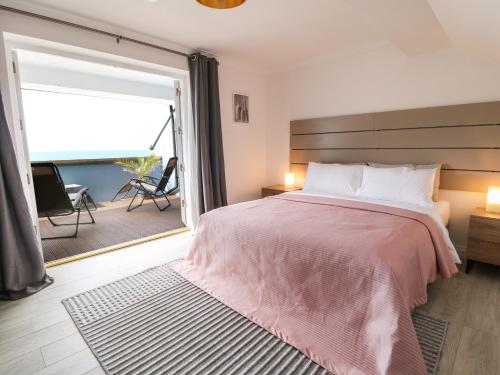 a bedroom with a large bed and a sliding glass door at The Blue Cottage in Portland