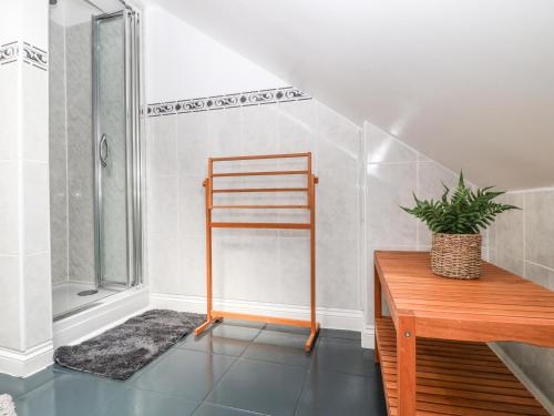 a bathroom with a shower and a wooden table at The Blue Cottage in Portland