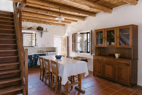 a kitchen with a table and chairs and a staircase at Villa Unica in Yiannioú