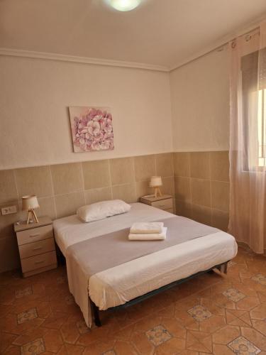 a bedroom with a bed and two lamps and a window at Casa Alboraya Valencia in Alboraya