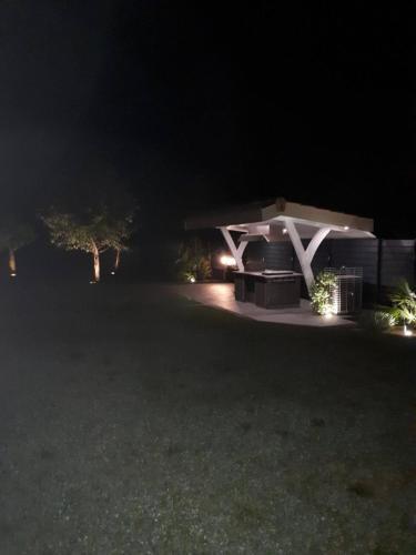 a pavilion at night with lights in the yard at Chambre 1 in La Brede