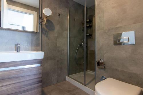 y baño con ducha, aseo y lavamanos. en Sleek & Modern 1BR Corner Flat w Views + Parking #191, en Estambul