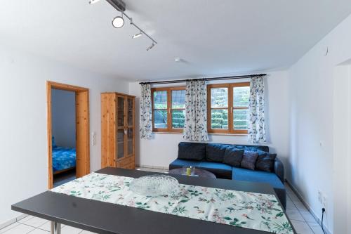 ein Wohnzimmer mit einem blauen Sofa und einem Tisch in der Unterkunft Ferienwohnung CasaNova in Finning
