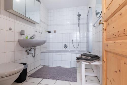 a bathroom with a tub and a sink and a toilet at Ferienwohnung CasaNova in Finning