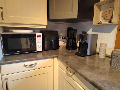 a kitchen counter with a microwave and a coffee maker at Ferienhaus Lathum früher Chalet Familienzeit in Lathum