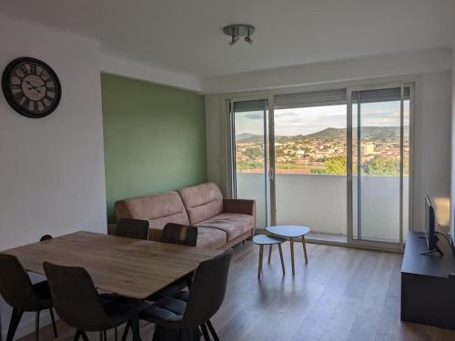 un salon avec une table et un canapé dans l'établissement Appartment - vue imprenable sur la cité médiévale - Parking gratuit - Climatisé, à Carcassonne