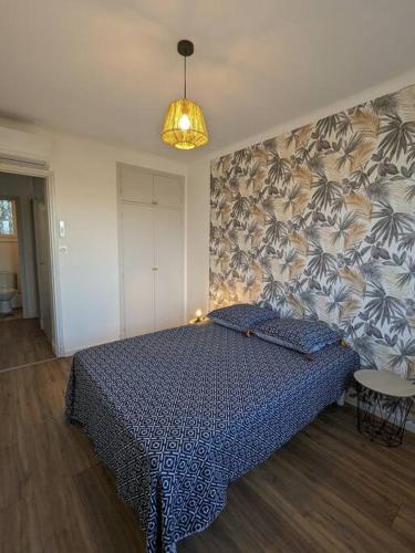 - une chambre avec un lit doté d'un couvre-lit bleu sur un mur dans l'établissement Appartment - vue imprenable sur la cité médiévale - Parking gratuit - Climatisé, à Carcassonne