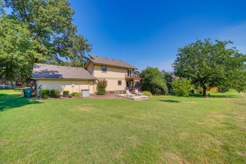 a home with a large yard with a house at Spacious Arkansas Abode with Balcony and Fire Pit! in Fort Smith