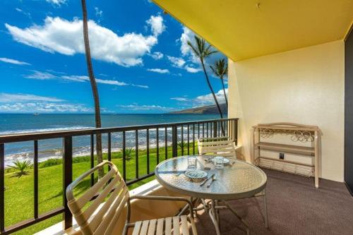 een balkon met een tafel en stoelen en de oceaan bij SUGAR BEACH RESORT #227 condo in Kihei