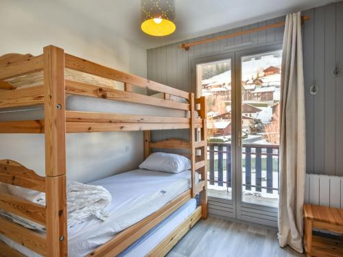 - une chambre avec 2 lits superposés et un balcon dans l'établissement Charmant T3 au coeur des Gets - 5 pers, proche remontées mécaniques et commerces - FR-1-685-2, aux Gets