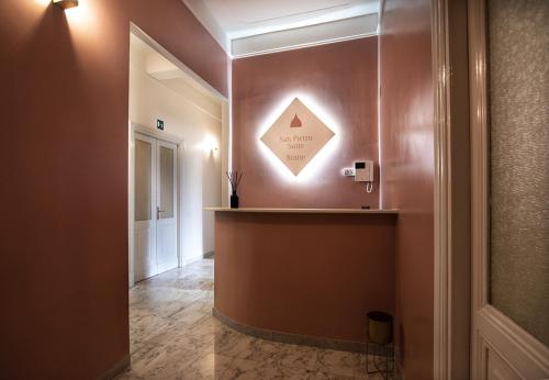 un pasillo con una pared con un cartel. en San Pietro Suite Rome, en Roma