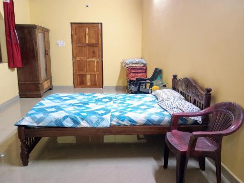 a bedroom with a bed and two chairs in it at The Grace Guest House in Salcete