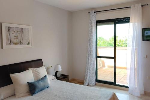 um quarto com uma cama e uma porta de vidro deslizante em Bonito apartamento en Marbella con piscina em Marbella
