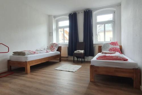 Roßwein的住宿－Monteurswohnung Roßwein - Zentral - Küche，带两张床和两个窗户的房间