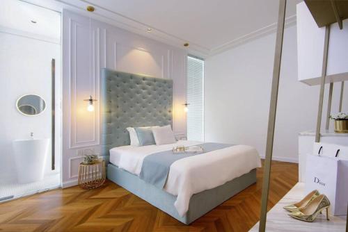 ein Schlafzimmer mit einem großen Bett mit blauem Kopfteil in der Unterkunft Georgetown Luxury Heritage House 4BR 10Pax in George Town