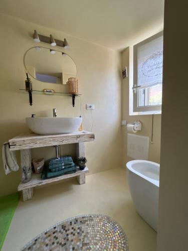 a bathroom with a sink and a tub and a mirror at A CASA DEL CONSOLE in Mondello