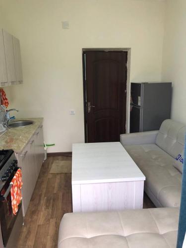 a living room with a white couch and a kitchen at Apartment.1 in Fergana