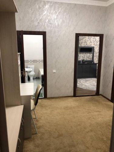 a bathroom with a mirror and a sink in a room at Apartment.1 in Fergana
