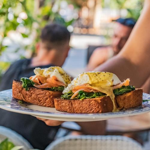 a person holding a plate with two sandwiches on it at De Pejoto in Tel Aviv