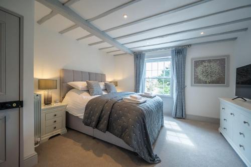 a bedroom with a bed and a television in it at Vine Cottage in Halford