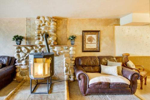 a living room with a leather couch and a fireplace at Main Street Townhome - 12 Miles to Bear Lake! in Paris