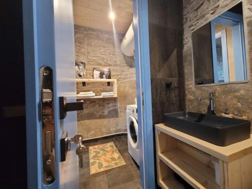 a bathroom with a sink and a washing machine at Melodia - Harmony Heaven in Gjirokastër