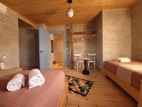 a bedroom with two beds and a table and a table at Melodia - Harmony Heaven in Gjirokastër