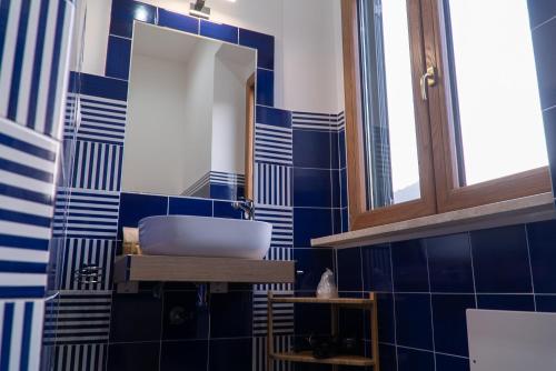 a blue tiled bathroom with a sink and a mirror at Mareterè in Vietri sul Mare