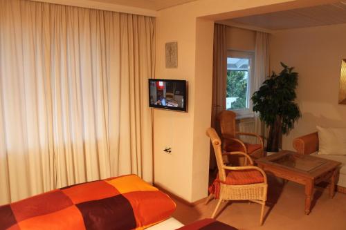 a bedroom with a bed and a table and a tv at Landhaus Goldenes Kreuz in Leutkirch im Allgäu