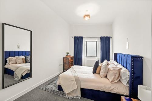 1 dormitorio con 2 camas y espejo en Luxury London Canary Wharf 2 bed apt, en Londres