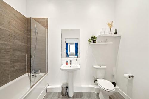 e bagno con servizi igienici, lavandino e doccia. di Luxury London Canary Wharf 2 bed apt a Londra