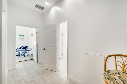 a white hallway with a bedroom and a bed at 3 Mi to Lakefront Beach St Cloud Apt in Ashton