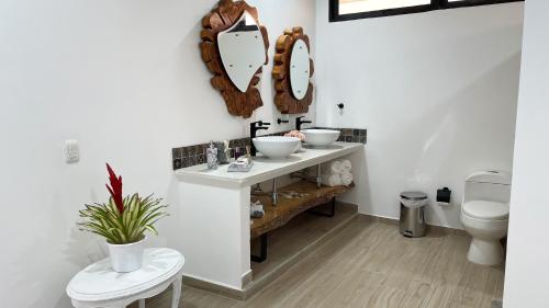 a bathroom with two sinks and a mirror on the wall at Aguas Claras Luxury Hospedaje in Filandia
