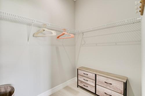 a bedroom with white walls and a wooden dresser at 3 Mi to Lakefront Beach St Cloud Apt in Ashton