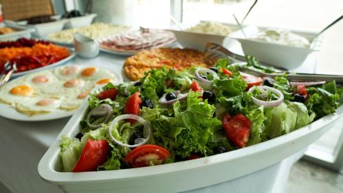 a table topped with a salad and other foods at Hotel Nobilis Hall in K'obulet'i