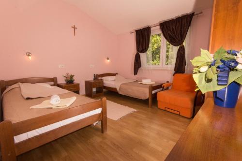 a room with two beds and a cross on the wall at Villa Petra in Međugorje