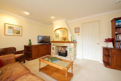 a living room with a couch and a fireplace at Badgers End in Chipping Campden