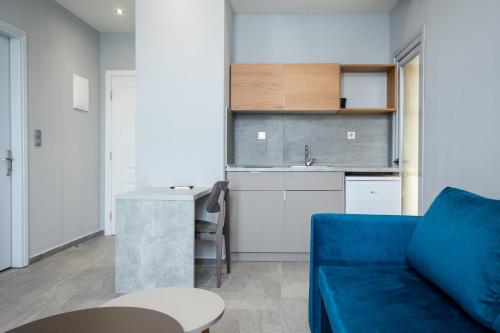 a living room with a blue couch and a kitchen at Aristotelous Downtown Suites in Thessaloniki