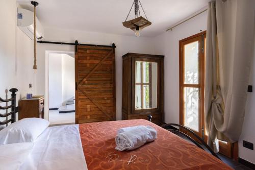 sypialnia z łóżkiem i drewnianymi drzwiami w obiekcie La tua dimora w mieście Sarzana