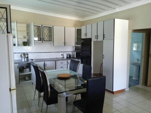 a kitchen with a glass table and chairs in it at Heberden chalets in Melville