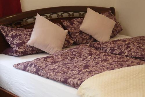 Una cama con almohadas moradas y blancas. en Charmantes Bauernhaus-Cottage 