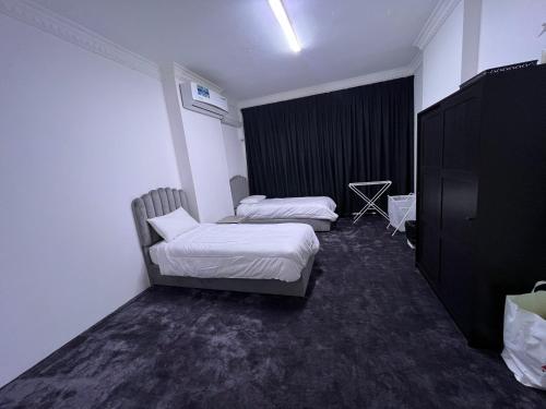 Habitación con 2 camas y una silla. en Dinar apartments - twin bed, en Abu Dabi