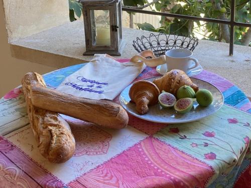 un tavolo con un piatto di pane e una tazza di caffè di Château de la Merletade a Cheval-Blanc