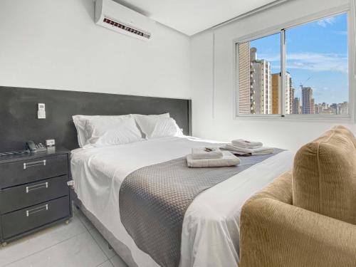 a bedroom with a bed with a chair and a window at Hotel na Vila Olimpia in Sao Paulo