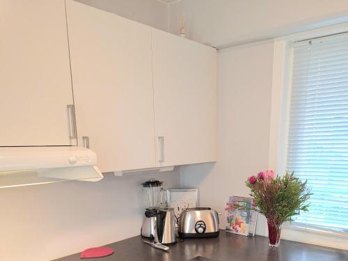 a kitchen with white cabinets and a counter top at Modern central apartment next to beautiful nature2424 in Oslo